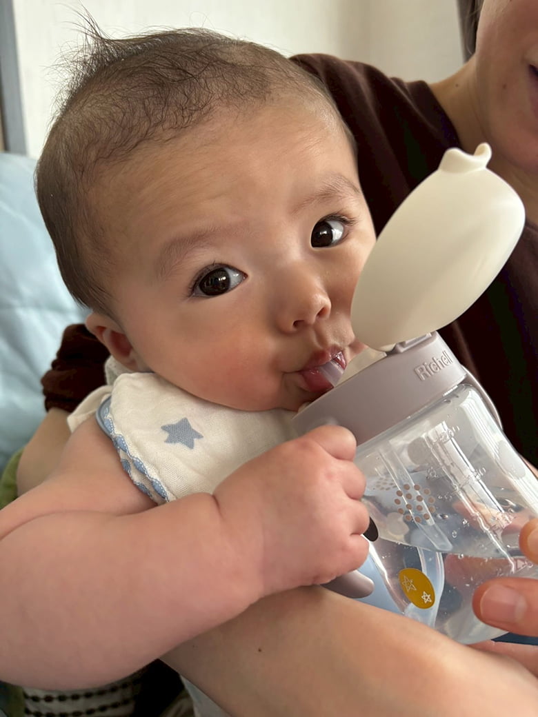 赤ちゃんが水を飲んでいる様子の写真