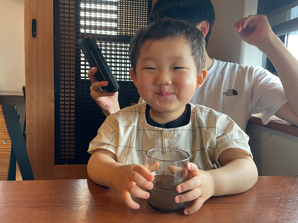 水を飲んでいる笑顔の子どもの写真